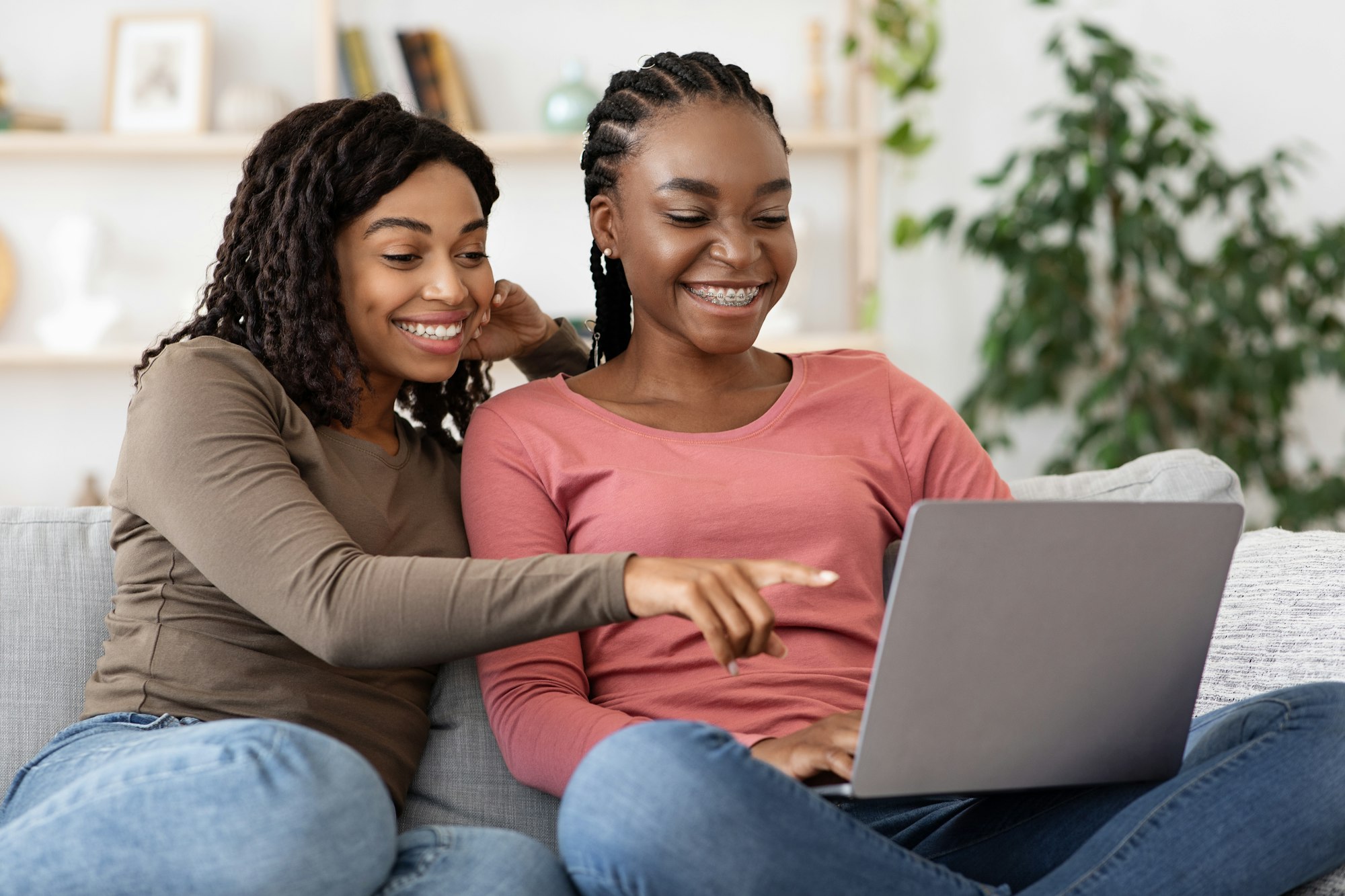 Happy black women using laptop at home, websurfing